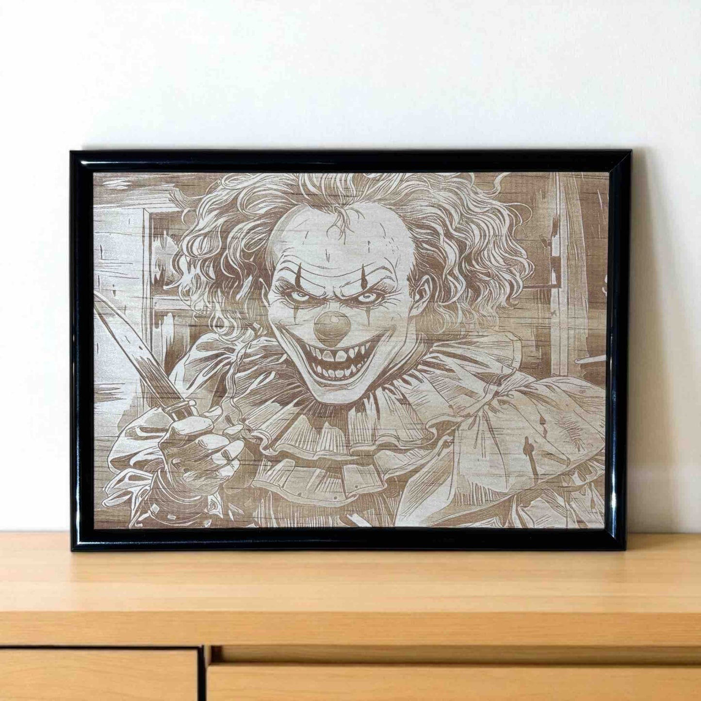 Framed artwork of a clown with a knife on a wooden surface