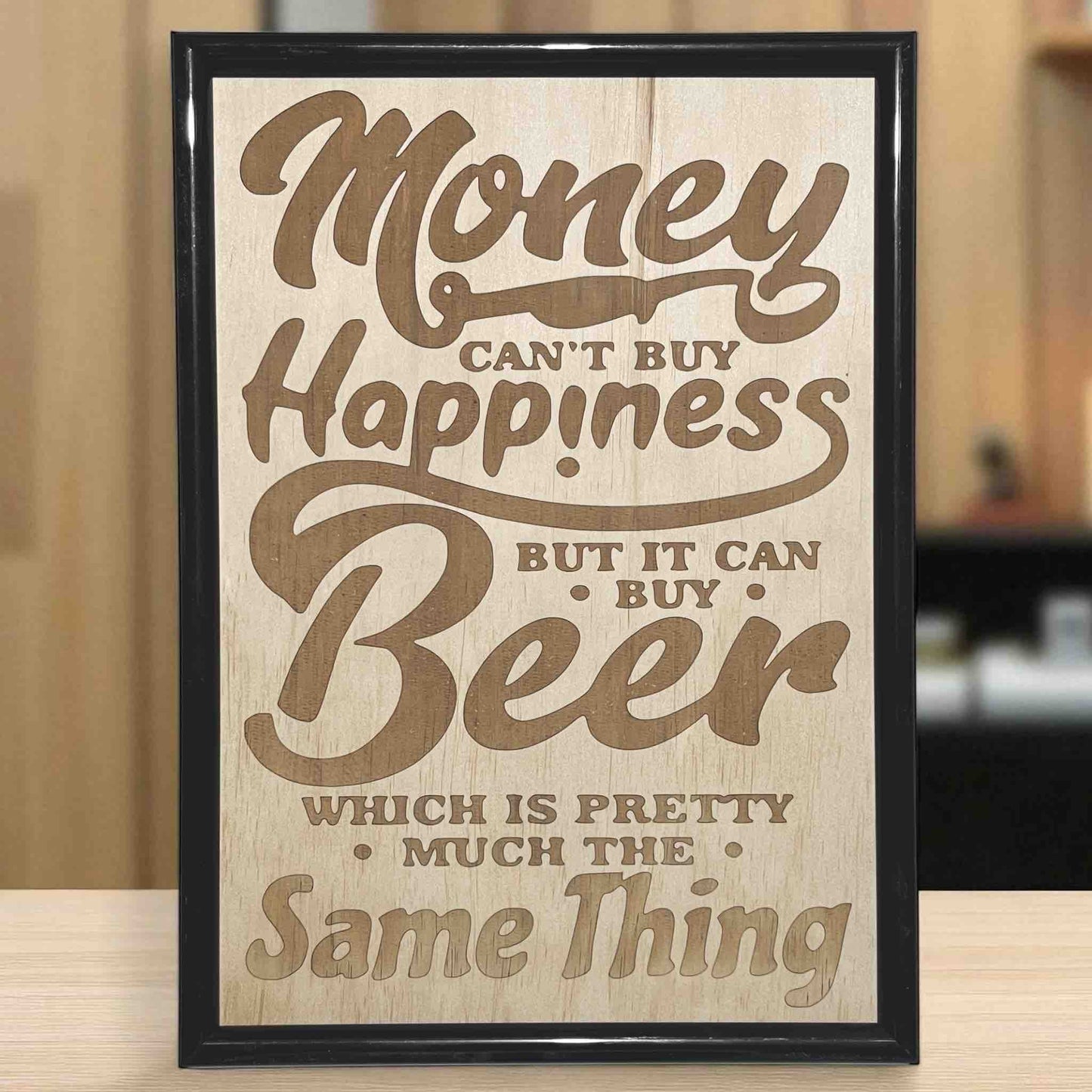 A wood sign with an engraved text that reads 'Money can't buy happiness but it can buy beer'. Australian Made. Laser Design Creations.