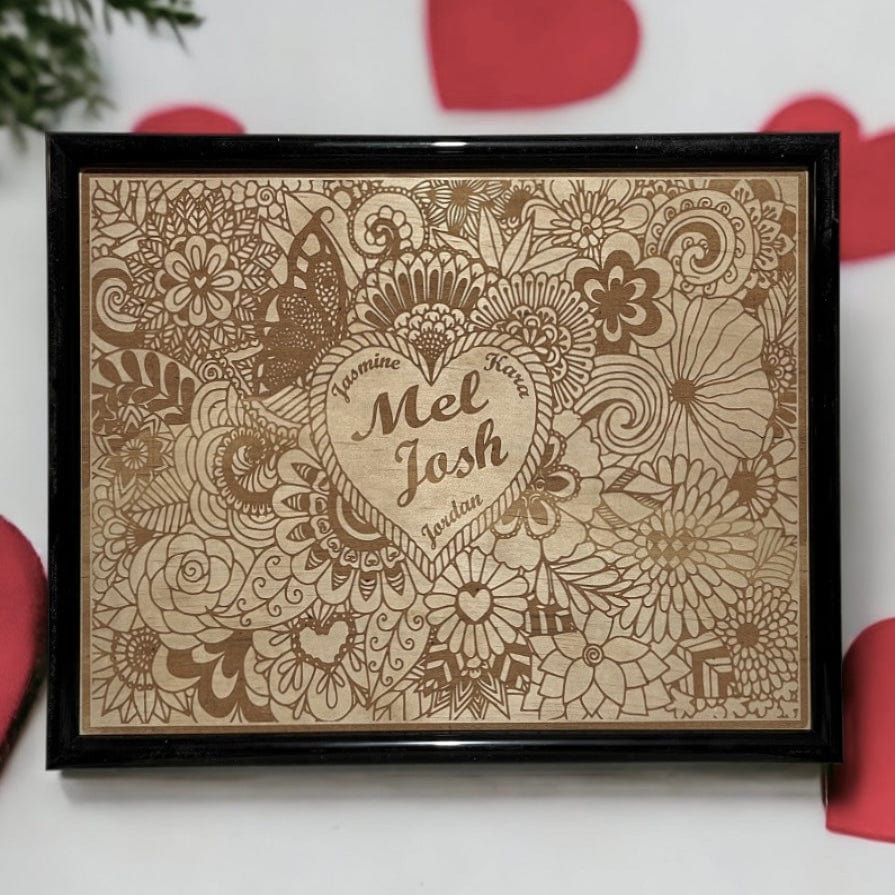 A wood engraved personalised floral heart design. It is displayed with red hearts and a wood grain background. Australian Made. Laser Design Creations