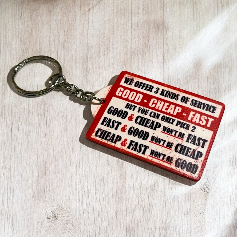 Side view of Three Kinds Service Good Cheap Fast keyring, showcasing the business service dilemma quote in a distressed retro sign style by Laser Design Creations.