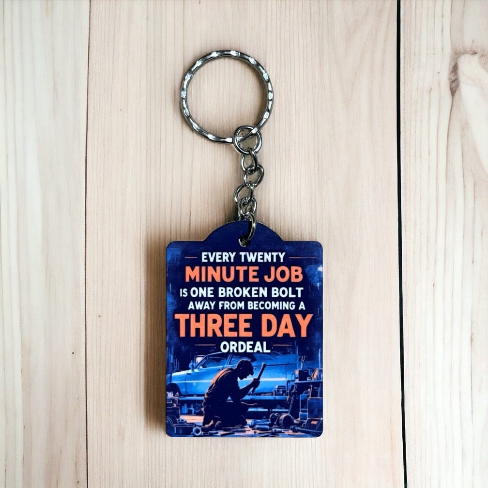 The Funny Broken Bolt Job Ordeal keyring by Laser Design Creations, featuring dark garage art style and the quote about job delays due to broken bolts.