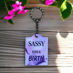 'Sassy Since Birth' Keyring by Laser Design Creations, featuring a humorous purple brushstroke quote design.