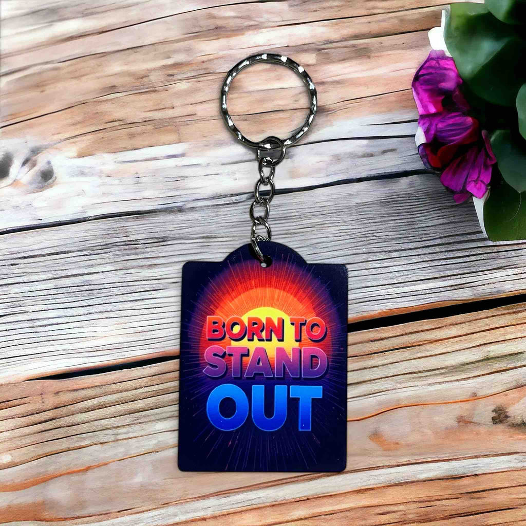 Born to Stand Out Radiant Design acrylic keyring by Laser Design Creations, featuring 'BORN TO STAND OUT' text in a bold, vibrant, and motivational style.
