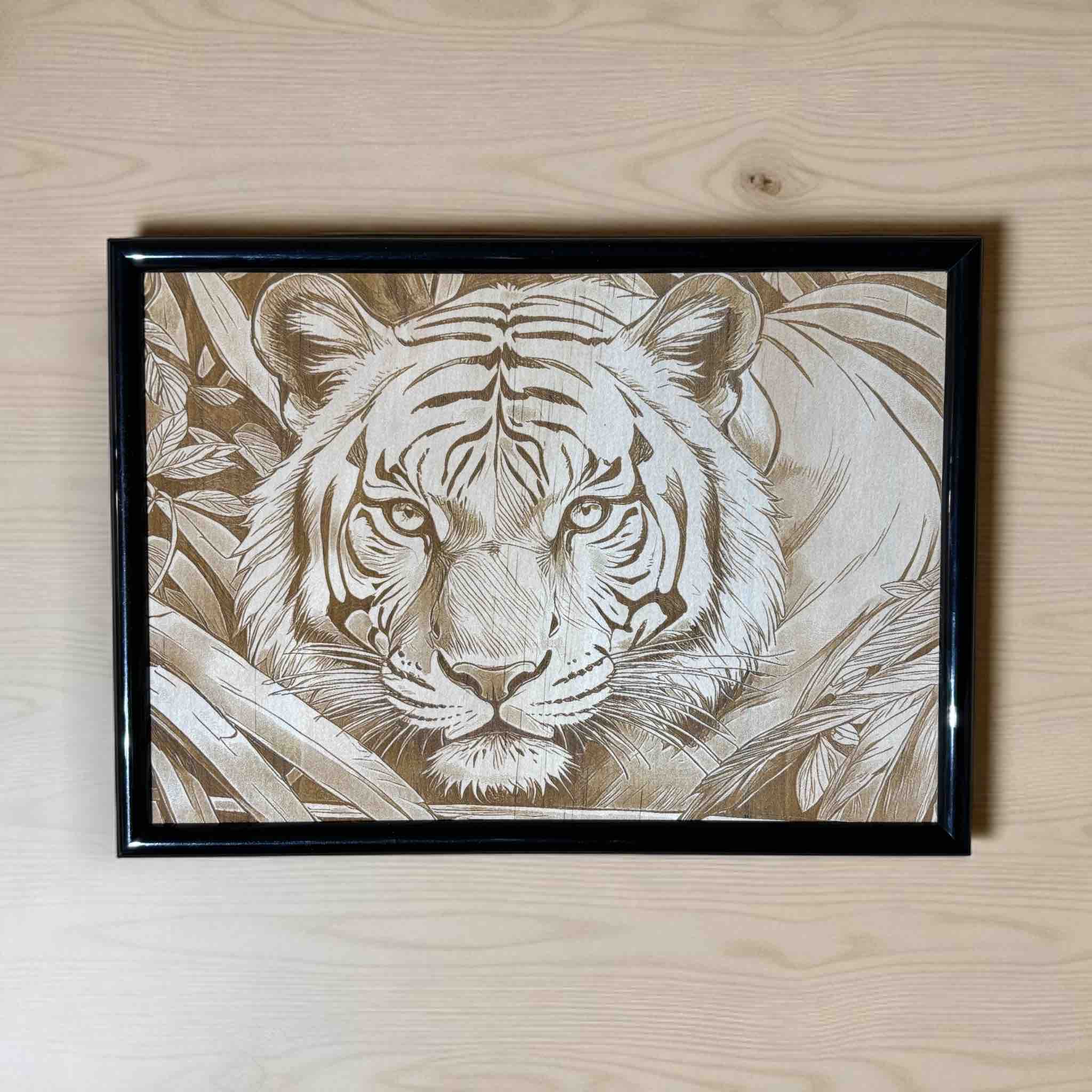 Framed artwork of a tiger on a wooden surface