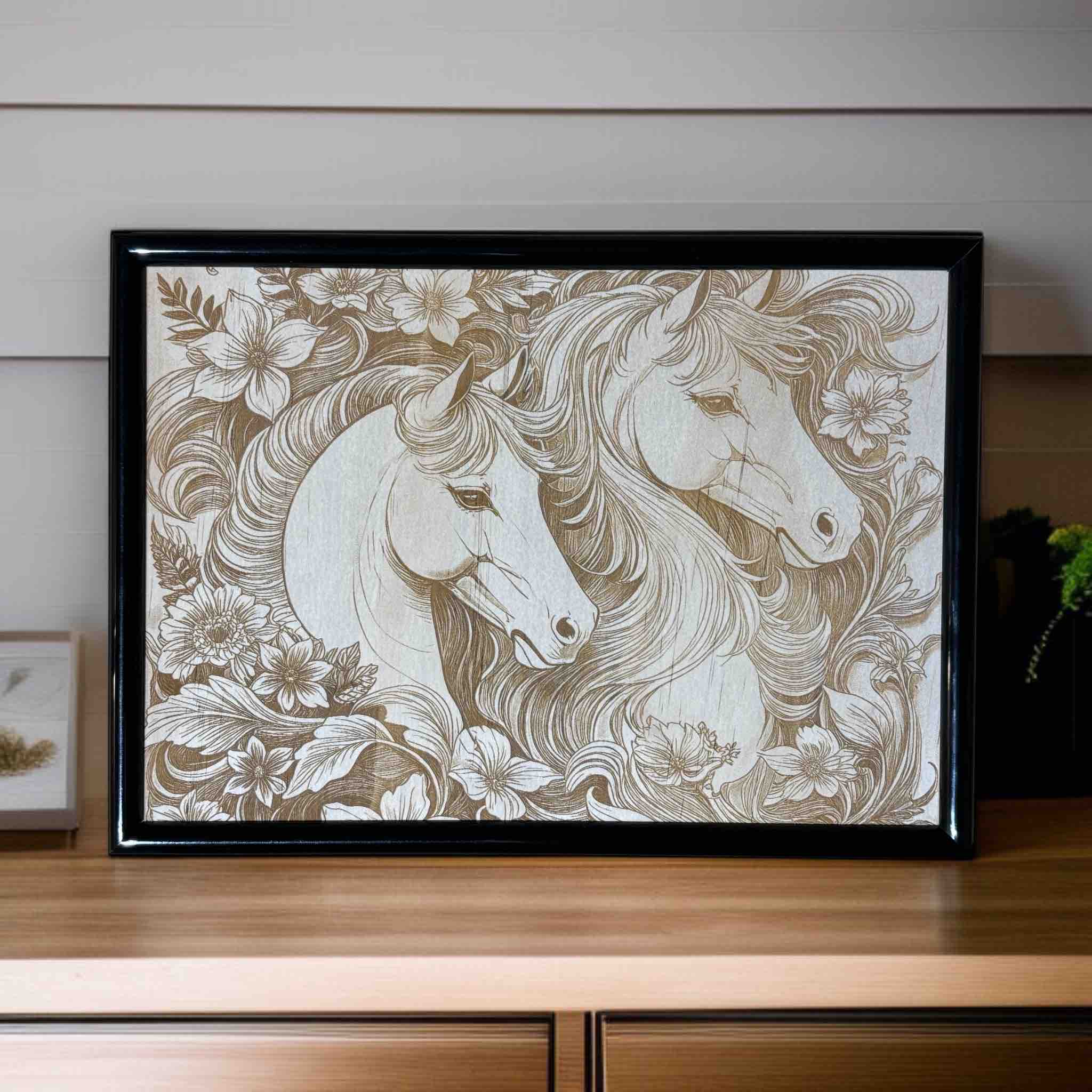Framed artwork of two horses intertwined with floral patterns on a wooden surface.