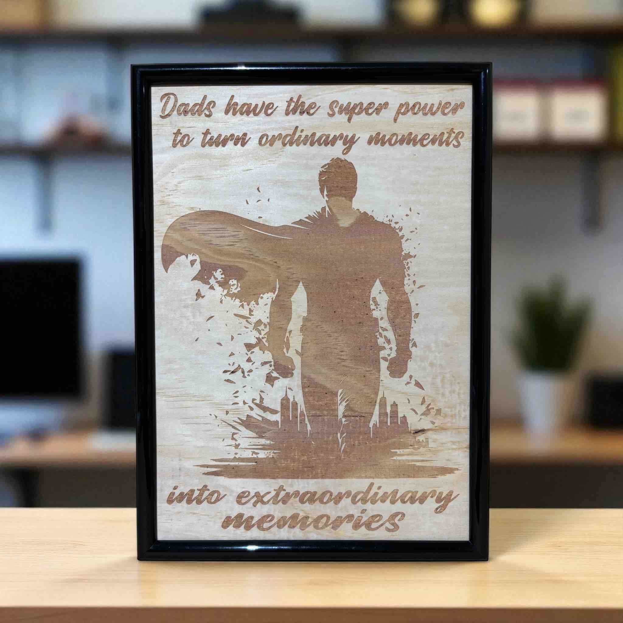 Wood engraved design featuring a superhero silhouette with the text 'Dads have the superpower to turn ordinary moments into extraordinary memories'. Australian Made by Laser Design Creations