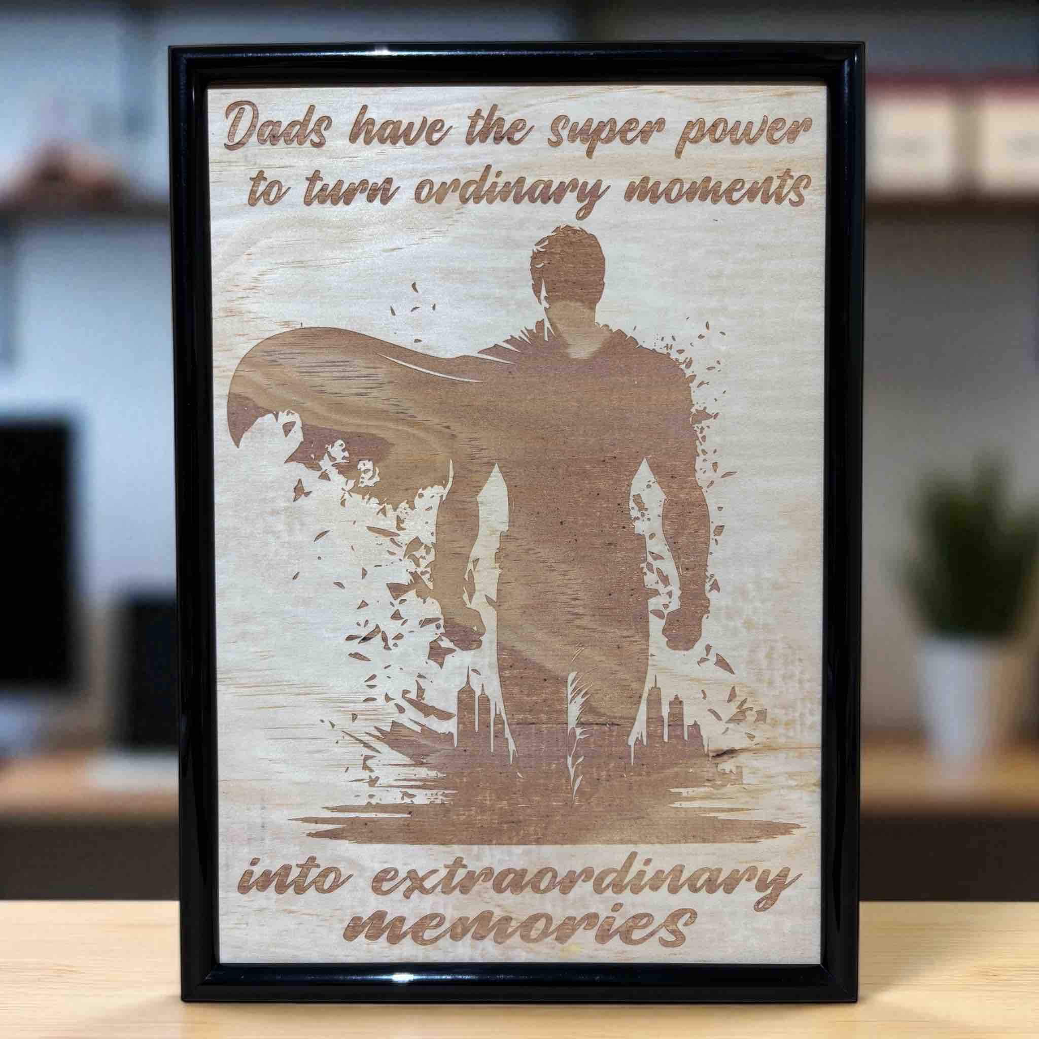 Wood engraved art design featuring a superhero silhouette with the text 'Dads have the superpower to turn ordinary moments into extraordinary memories'. Australian Made, Laser Design Creations