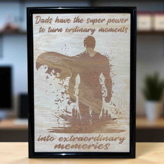 Wood engraved art design featuring a superhero silhouette with the text 'Dads have the superpower to turn ordinary moments into extraordinary memories'. Australian Made, Laser Design Creations