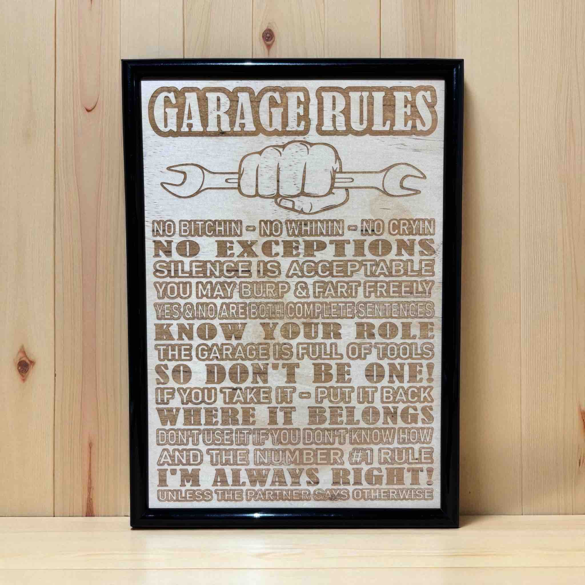 Garage Rules wood engraved sign displayed on grey workbench, humorous shed and workshop wall decor, Laser Design Creations, Australia.