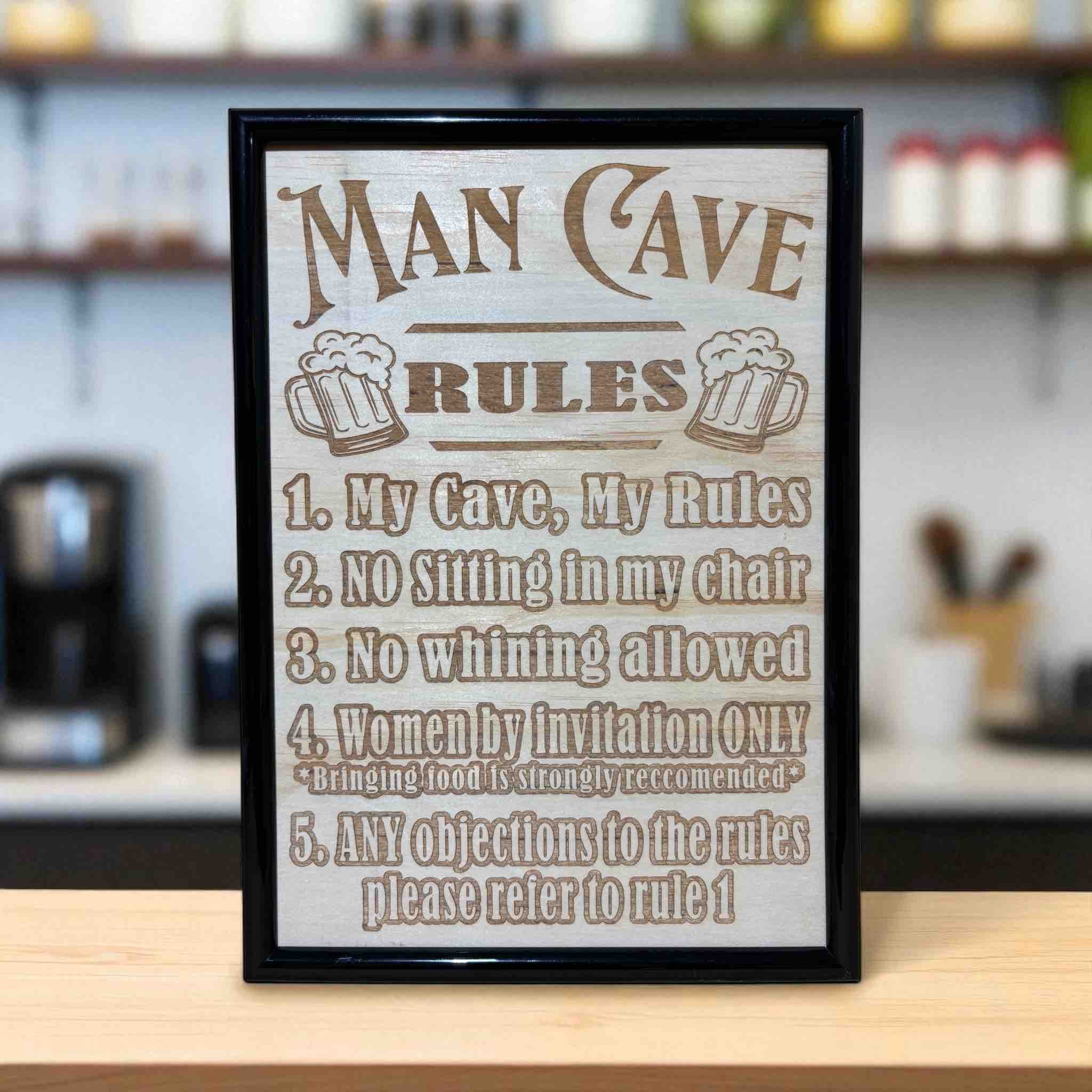 Man Cave Rules wood engraved sign displayed on bar counter, humorous home bar wall art, Laser Design Creations, Australia.