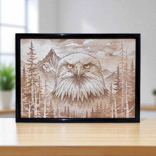 Wood engraved art of a majestic eagle in mountain pines, framed by Laser Design Creations.
