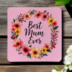 Top view of four 'Best Mum Ever' neoprene coasters with a watercolour flower design on a pink background, by Laser Design Creations.
