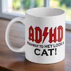 ADHD Highway to Hey Look a Cat ceramic mug by Laser Design Creations, featuring a funny rock band logo parody.