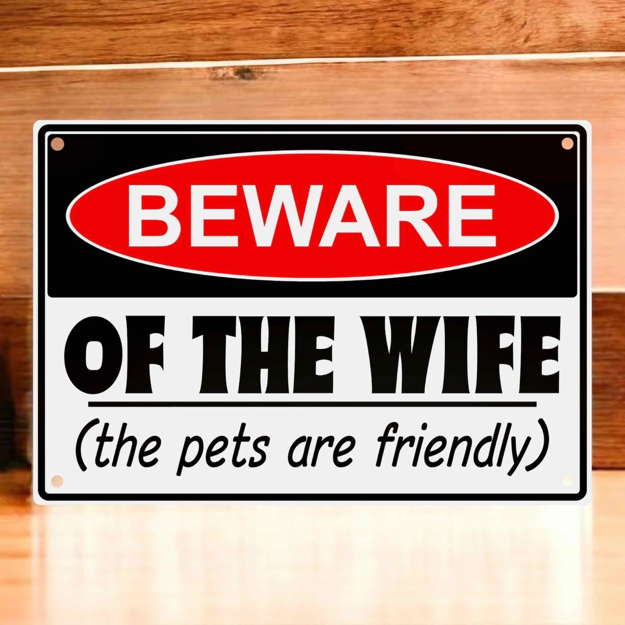 Novelty Warning Sign Parody Aluminium Sign by Laser Design Creations, featuring the quote 'BEWARE OF THE WIFE (the pets are friendly)' directed at husbands and guests.