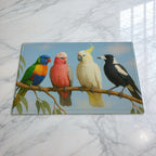 Aussie birds on a gum branch glass chopping board by Laser Design Creations, featuring a colourful Rainbow Lorikeet, pink Galah, white Cockatoo, and Australian Magpie perched on a leafy eucalyptus branch.