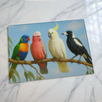 Vibrant native Australian wildlife art glass chopping board from Laser Design Creations featuring a beautiful illustration of iconic Aussie birds like the Galah, Lorikeet, Cockatoo, and Magpie resting on a green gum tree branch.