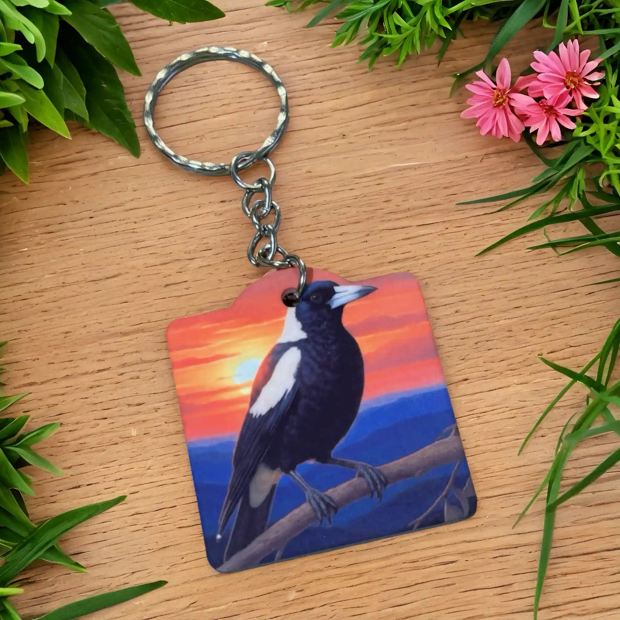 Side view of Australian Magpie Sunset Acrylic keyring, showcasing a vibrant painterly illustration of an Australian magpie perched on a branch against a sunset sky by Laser Design Creations.