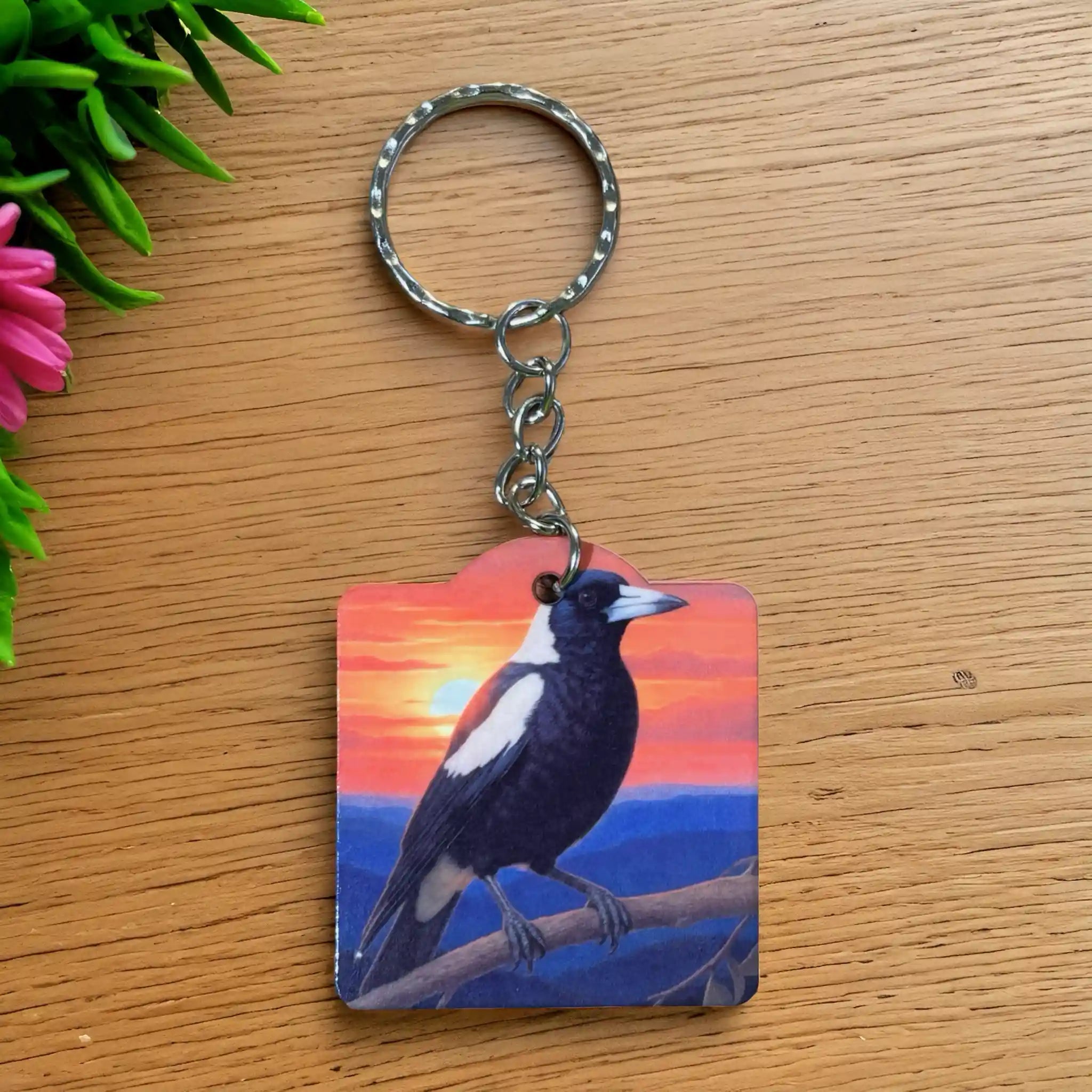 Australian Magpie Sunset Acrylic keyring by Laser Design Creations, featuring a vibrant painterly illustration of an Australian magpie perched on a branch against a warm sunset sky.