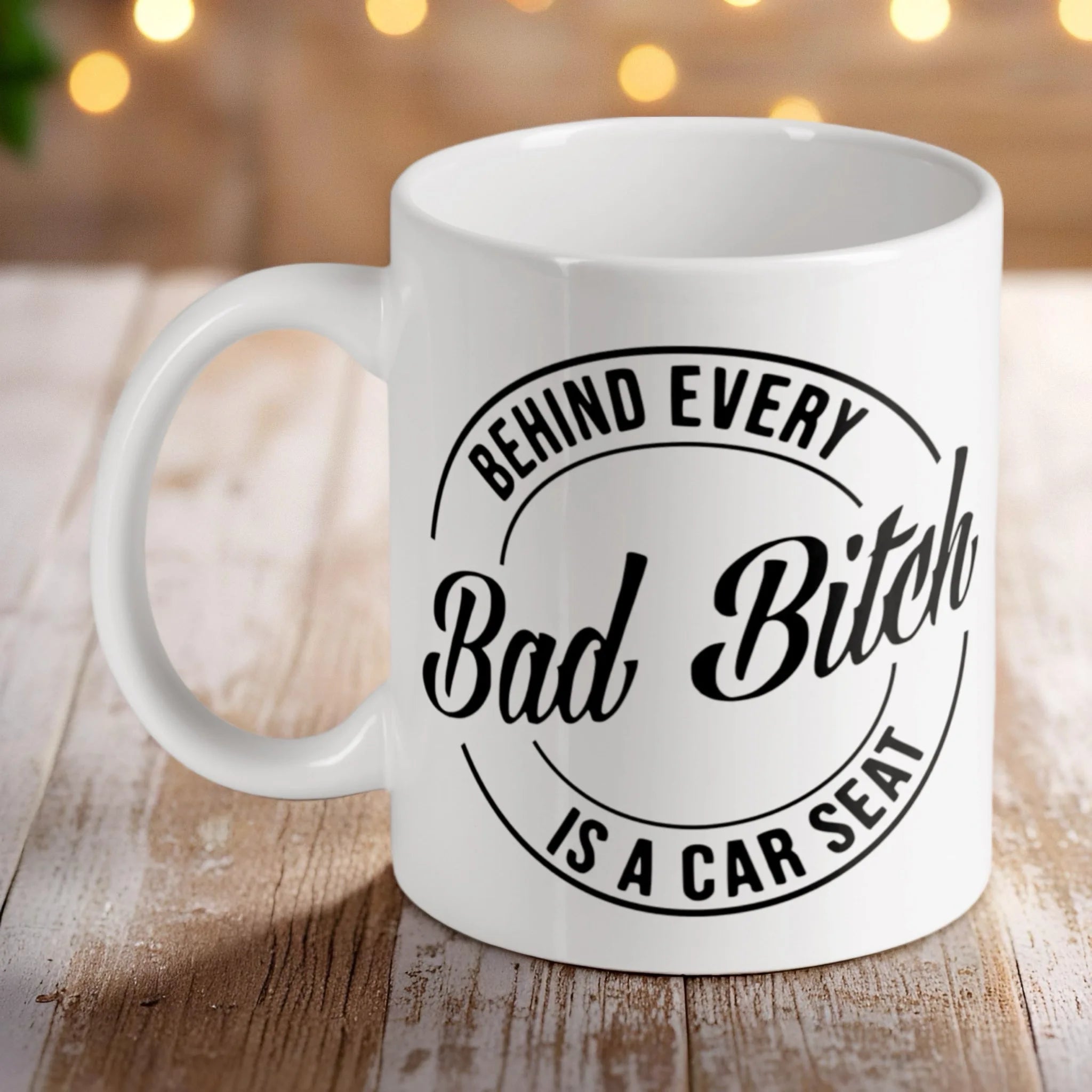 'Behind Every Bad Bitch is a Car Seat' ceramic mug by Laser Design Creations, featuring a funny quote for mums.