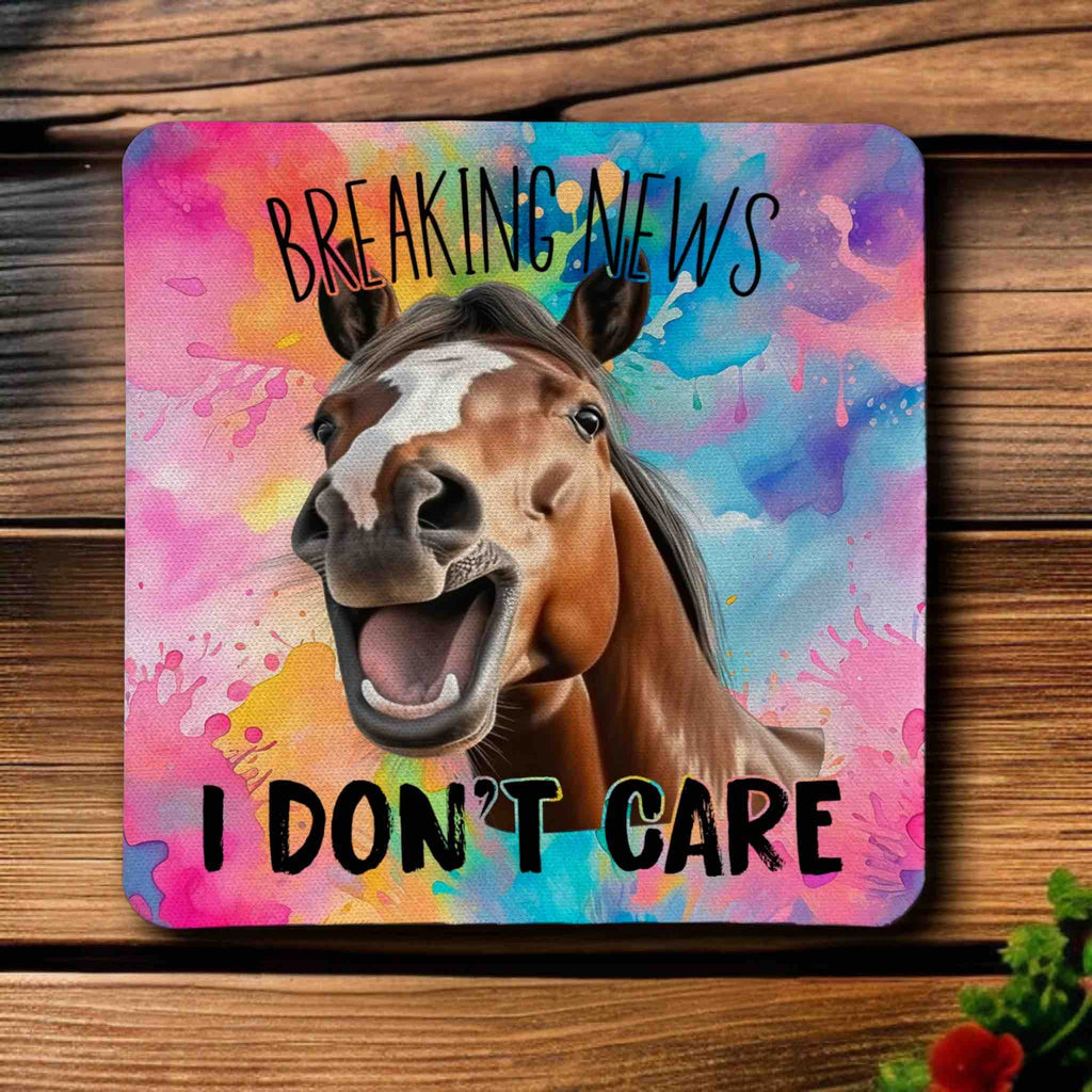 Top view of a set of four Sarcastic 'Breaking News I Don't Care' horse neoprene coasters with a laughing horse against a colourful background, by Laser Design Creations.