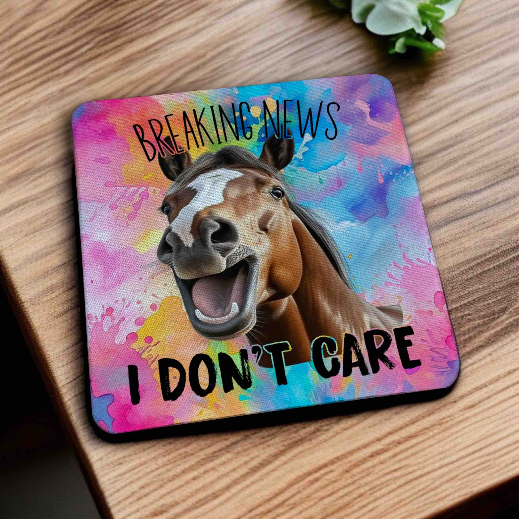 Side view of a set of four Sarcastic 'Breaking News I Don't Care' horse neoprene coasters with a laughing horse, by Laser Design Creations.