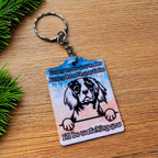 Side view of Every Move You Make Cavalier keyring, showcasing a humorous watercolour illustration of a Cavalier King Charles Spaniel dog with the text Every move you make Every breath you take I'll be watching you on a neutral background by Laser Design Creations.