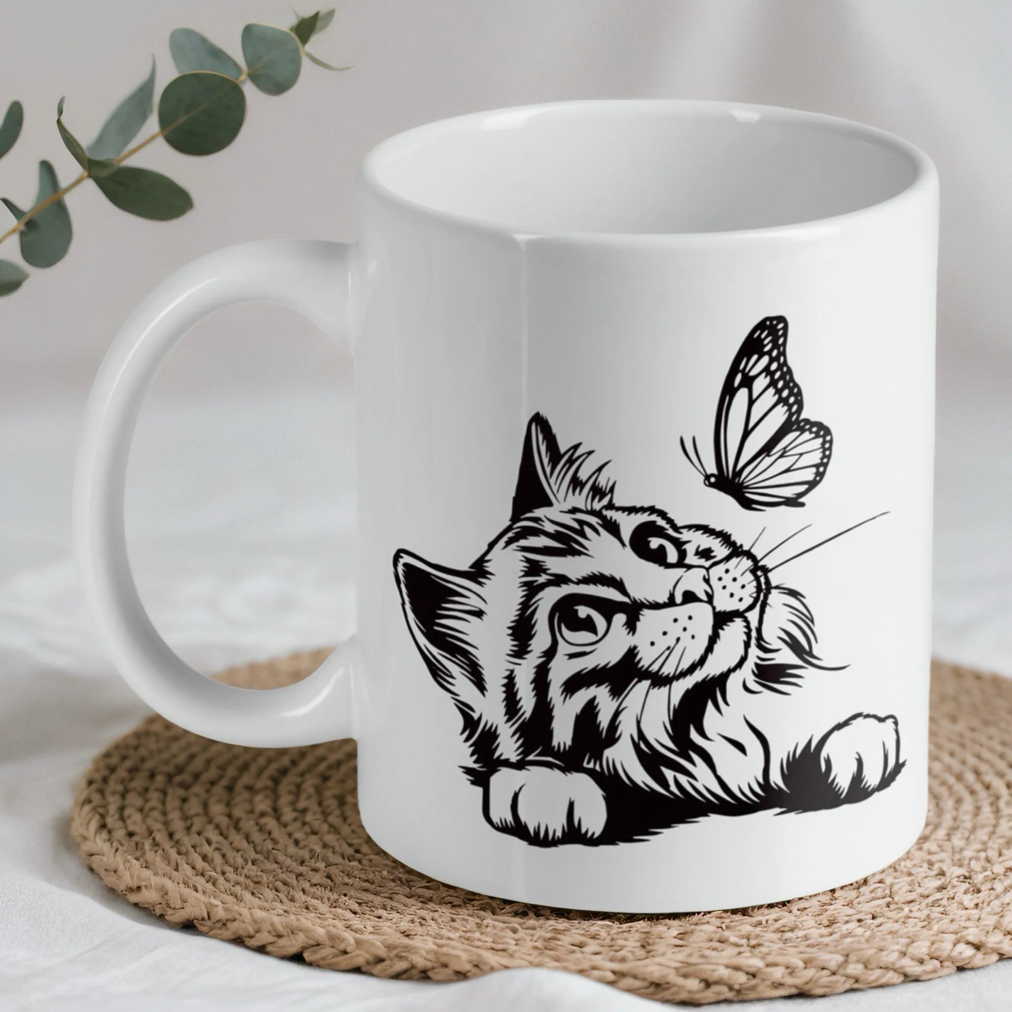 Cat and butterfly line art ceramic mug by Laser Design Creations, featuring a black line art illustration of a fluffy cat looking at a butterfly on a white background.