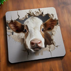 Side view of Clever 3D Peekaboo Cow neoprene coasters, showcasing a playful 3D optical illusion of a cow peeking through a cracked rustic farmhouse wall by Laser Design Creations.