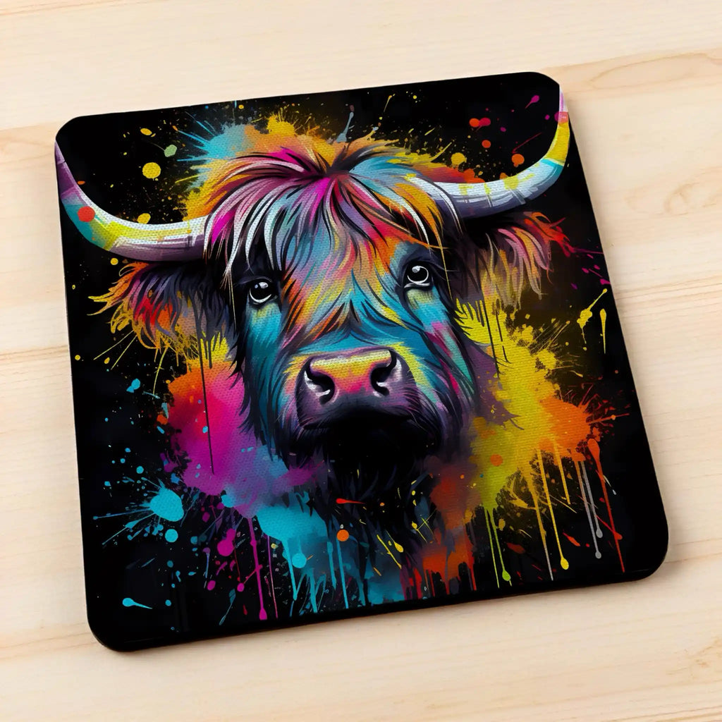 Side view of Colour Splash Highland Cow style 4 neoprene coasters, showcasing an artistic shaggy cow with vibrant paint splatters against a neutral background by Laser Design Creations.