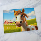 Cute cartoon spotted pony glass chopping board from Laser Design Creations featuring a whimsical smiling 3D pony design set against a colourful background.