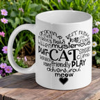 Feline Best Friend Word Cloud ceramic mug by Laser Design Creations, featuring a heart-shaped word cloud about cats on a white ceramic mug, set against a leafy green background.