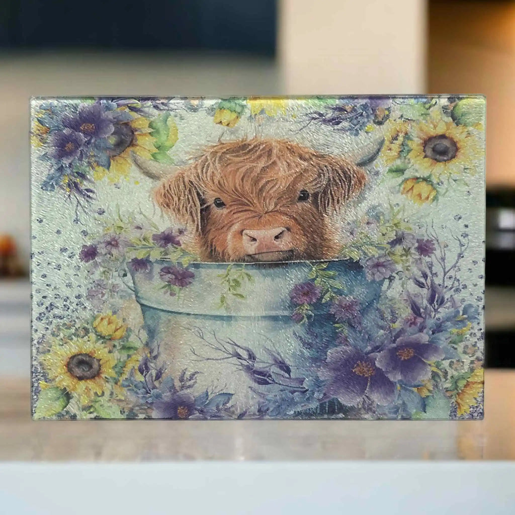 A painterly-style design of a cute Highland calf sitting in a metal bucket filled with bright yellow sunflowers chopping board from Laser Design Creations