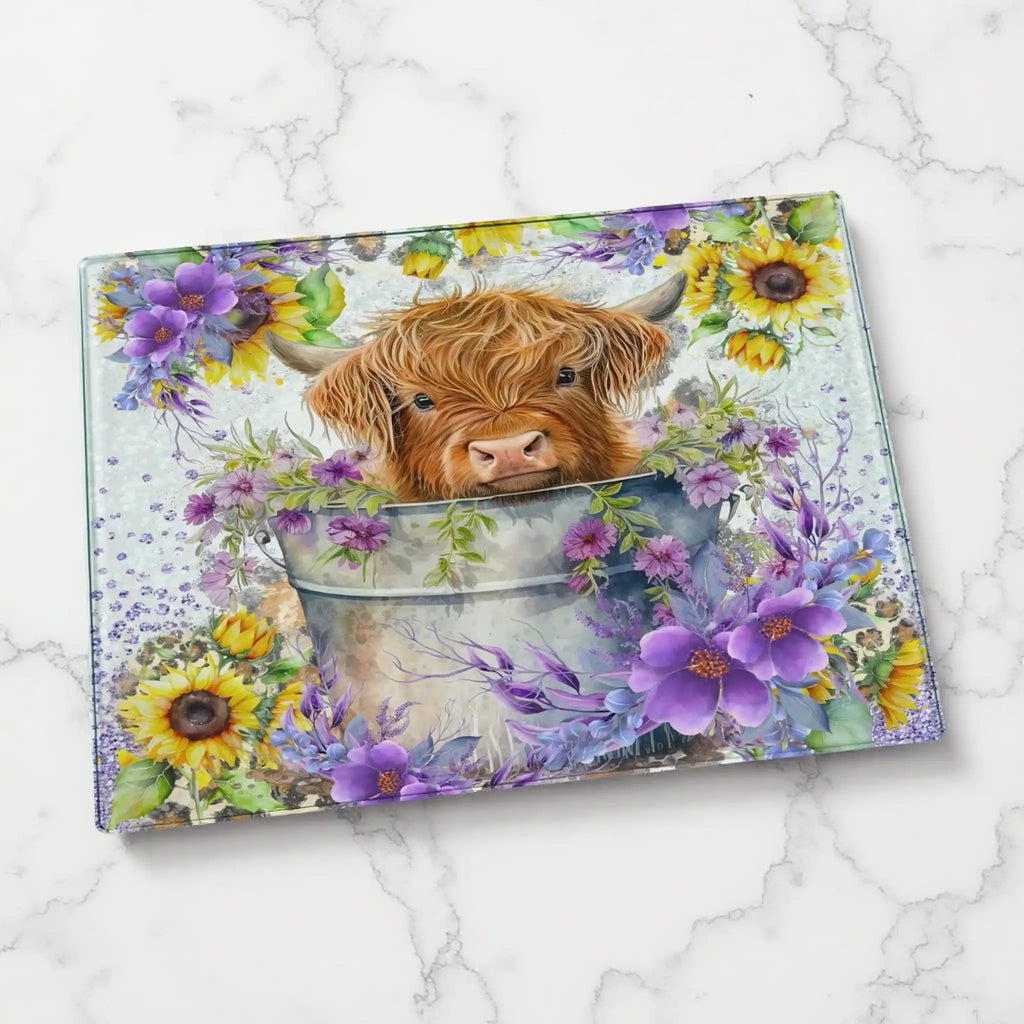 Cute Highland Calf in Bucket with Sunflowers chopping board by Laser Design Creations, featuring a fluffy baby Highland cow surrounded by vibrant sunflowers. Displayed on a marble countertop.