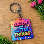 Side view of the Enjoy The Little Things - Funky Rainbow Confetti Design keyring, showcasing motivational quote typography set against a vibrant rainbow confetti background by Laser Design Creations.