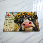 Cheeky Highland Cow chopping board by Laser Design Creations, featuring a funny quote about being too tired on a textured glass background.