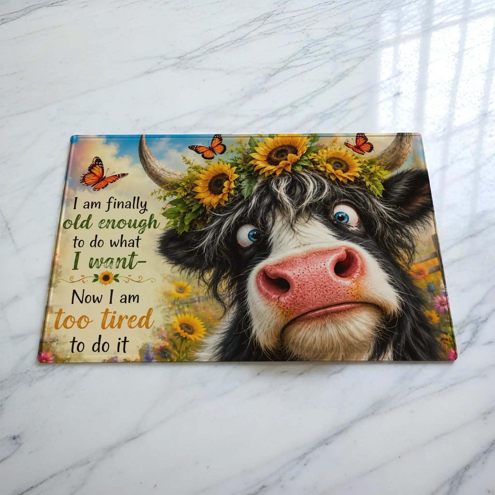 Cheeky Highland Cow chopping board by Laser Design Creations, featuring a funny quote about being too tired on a textured glass background.