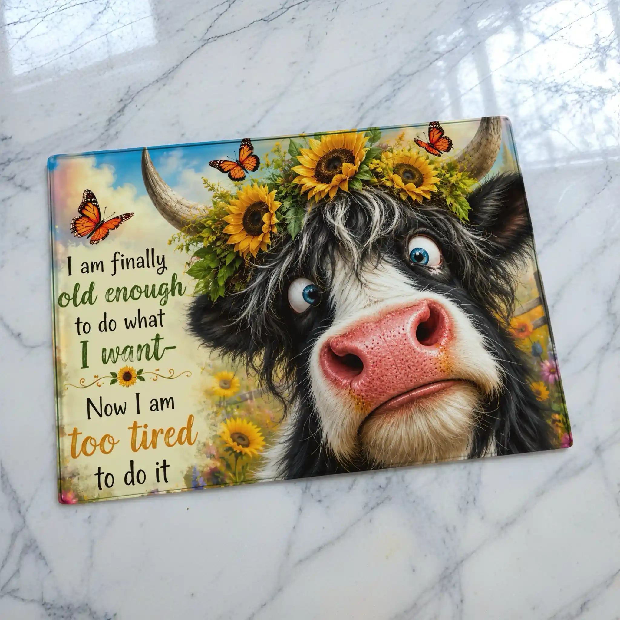 Funny highland cow illustration chopping board from Laser Design Creations featuring the humorous quote, I am finally old enough to do what I want, now I am too tired to do it, on a sleek glass background.