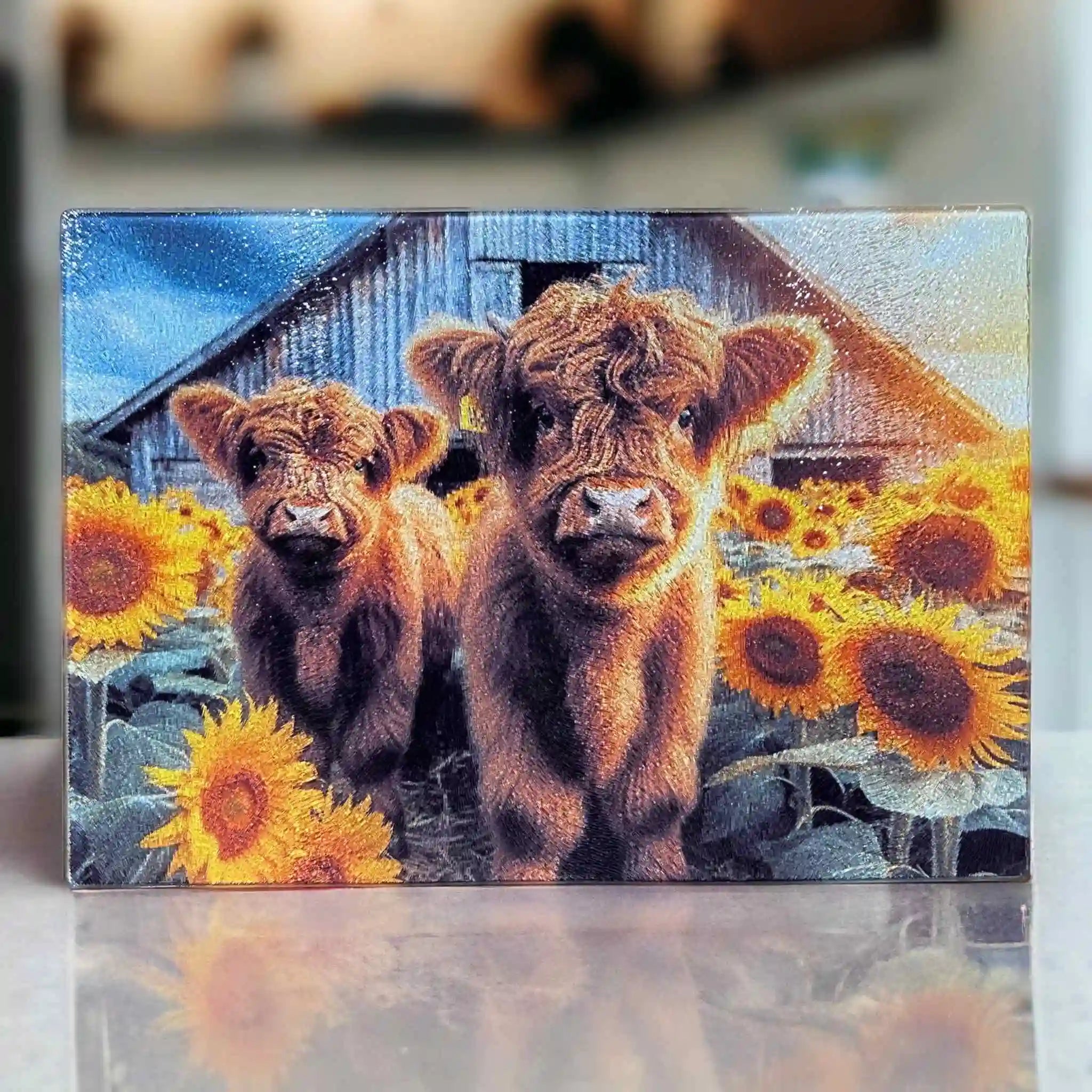 A vibrant farmhouse-style design featuring two fluffy Highland calves standing in a sunny sunflower field chopping board from Laser Design Creations