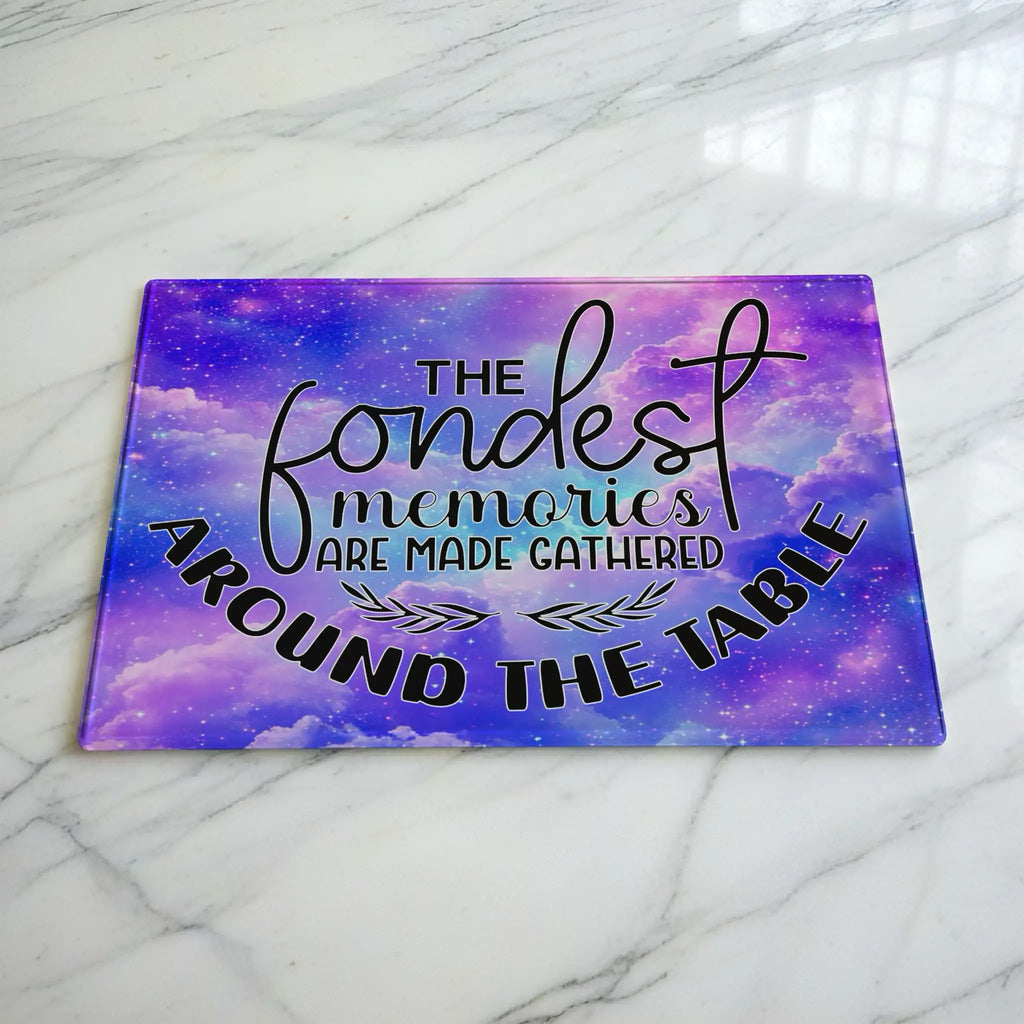 Fondest Memories Quote Purple Galaxy glass chopping board by Laser Design Creations, featuring the heartwarming quote, THE fondest memories ARE MADE GATHERED AROUND THE TABLE, set against a whimsical starry space nebula.