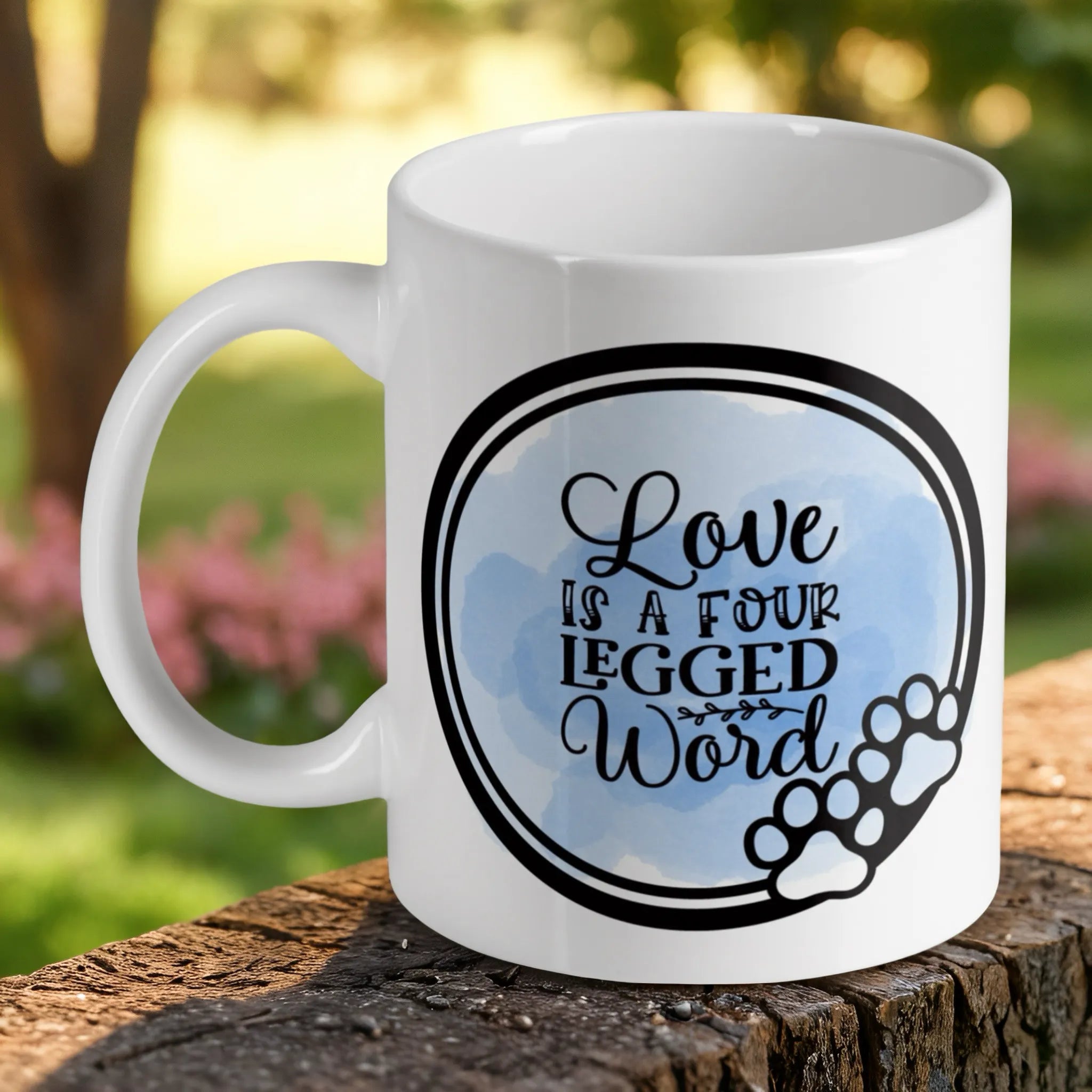 Love Is A Four Legged Word Quote ceramic mug by Laser Design Creations, featuring a charming watercolour design with a paw print graphic and blue accents.