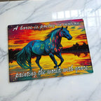 Vibrant colourful expressionist horse sunset chopping board from Laser Design Creations featuring a silhouette of a horse in motion with the text a horse is poetry in motion painting the world with grace over a glowing sunset.