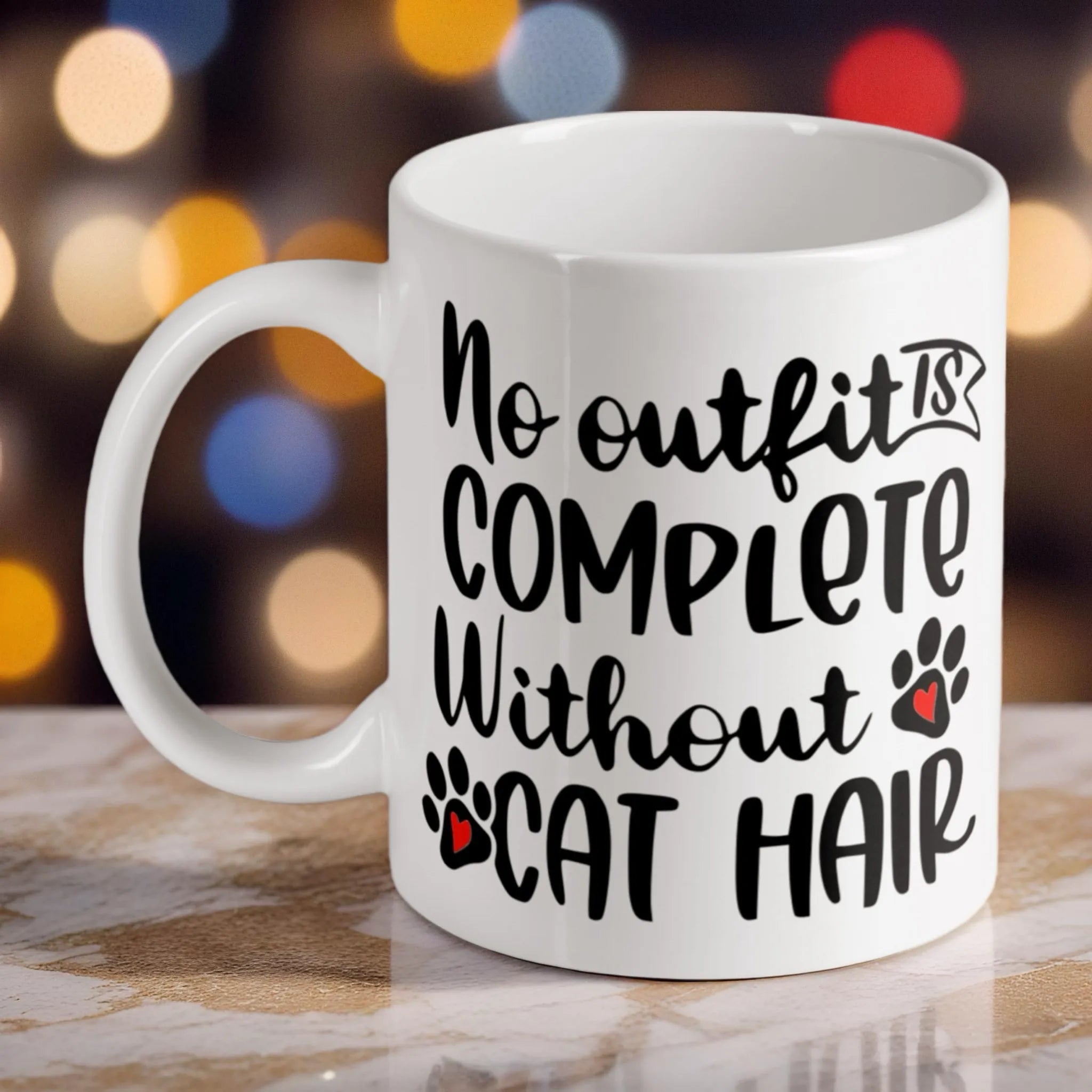"No Outfit is Complete Without Cat Hair" ceramic mug by Laser Design Creations, featuring a humorous quote for cat lovers on a white background.