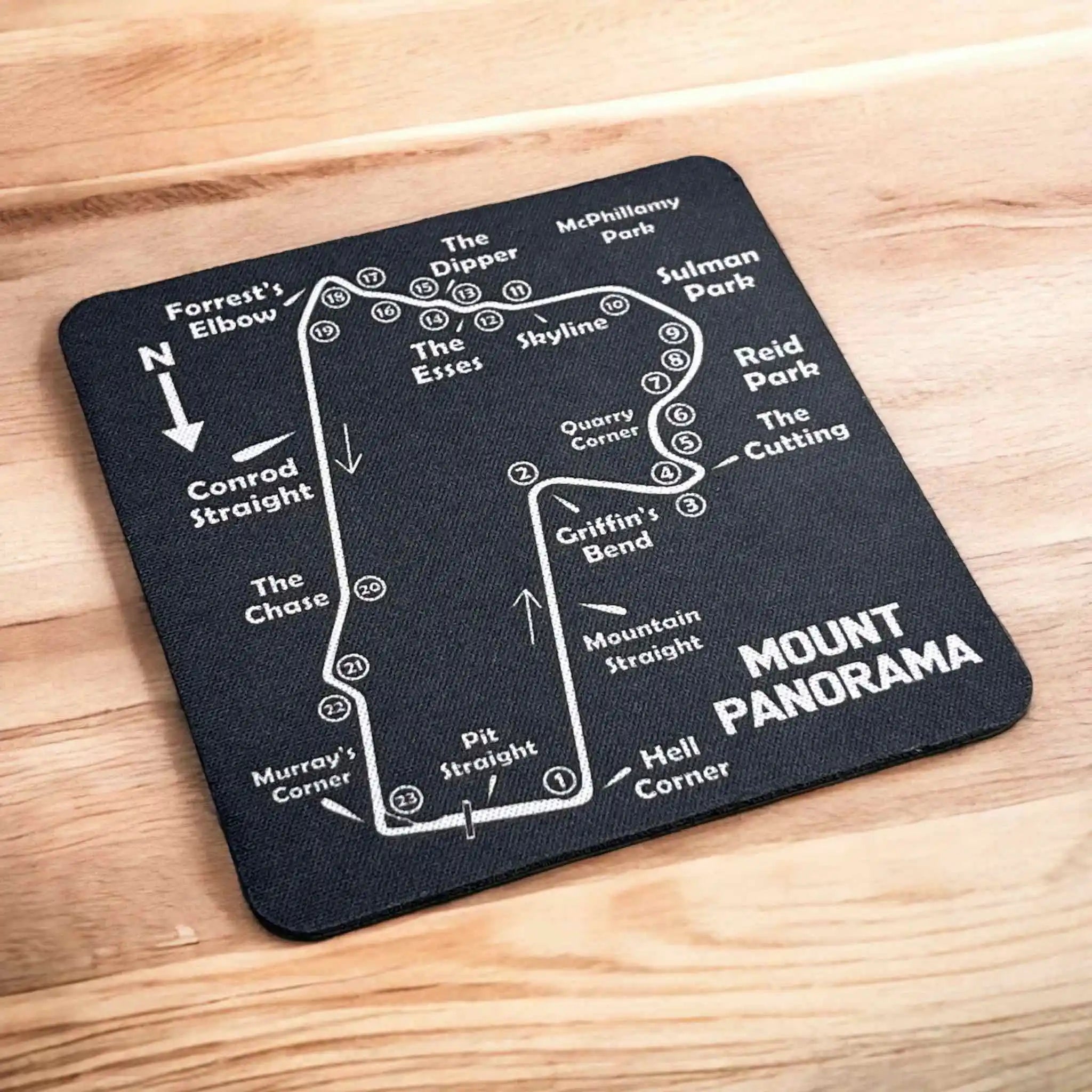 Side view of a stack of four Bathurst Mount Panorama map neoprene coasters, highlighting the non-slip backing, by Laser Design Creations.