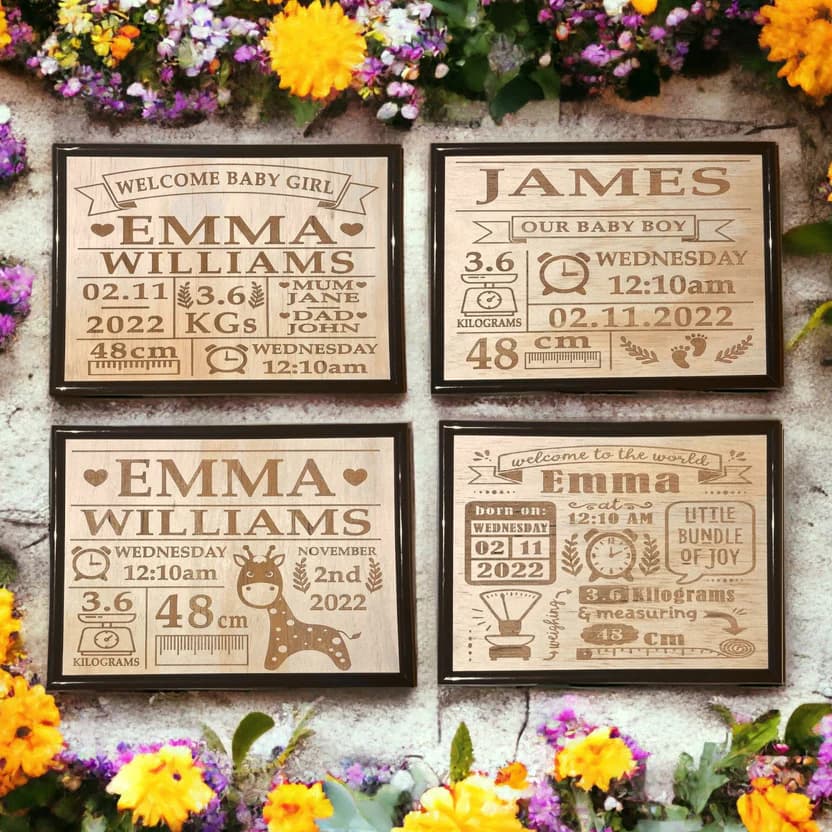 A collection of four personalized wooden plaques with engraved baby name birth details, displayed against a floral background.