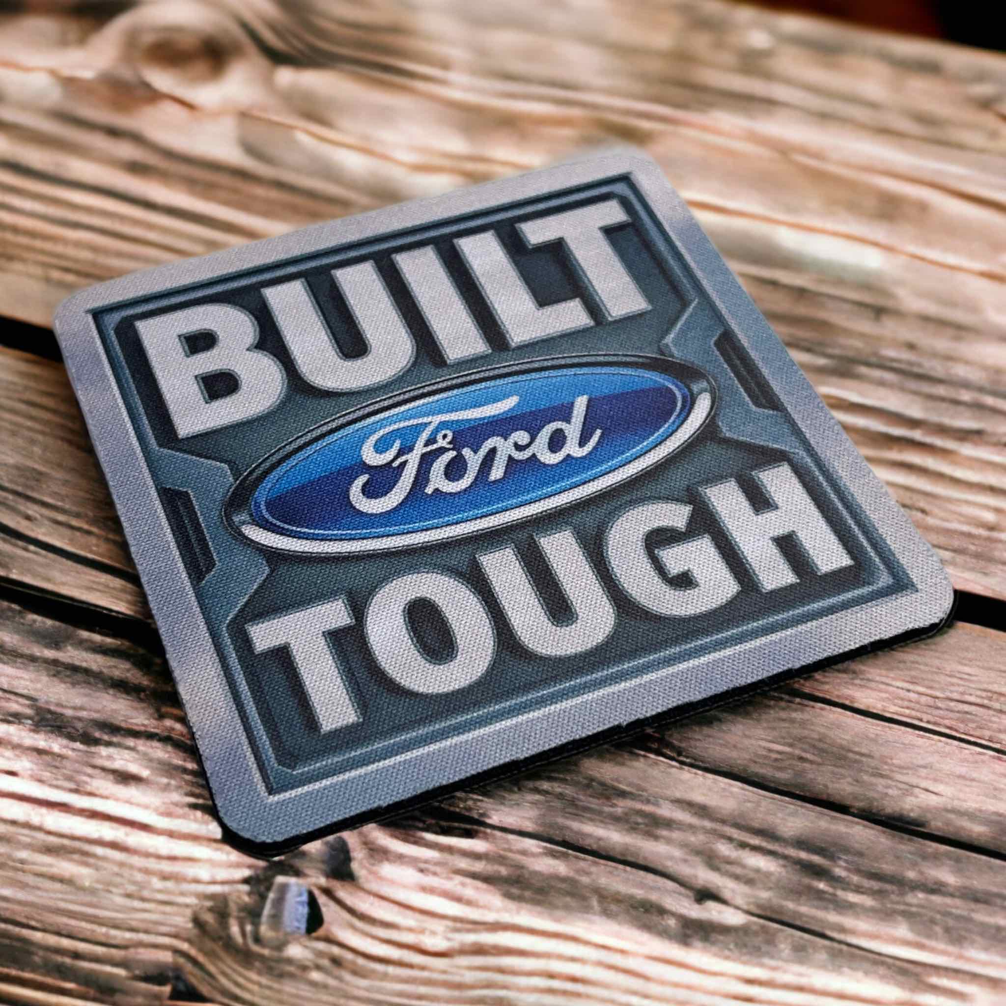 Side view of BUILT Ford TOUGH Emblem neoprene coasters, showcasing the bold automotive text design and industrial aesthetic by Laser Design Creations.