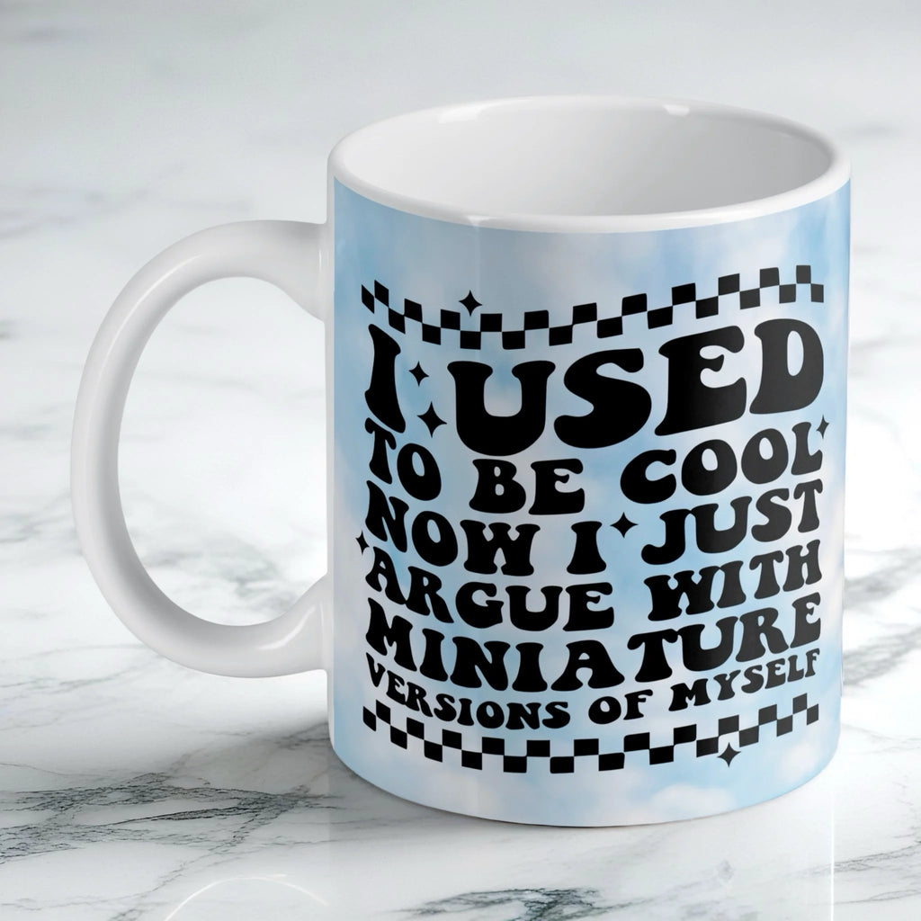 I Used To Be Cool ceramic mug by Laser Design Creations, featuring retro wavy text and blue clouds with blue and white checkers.