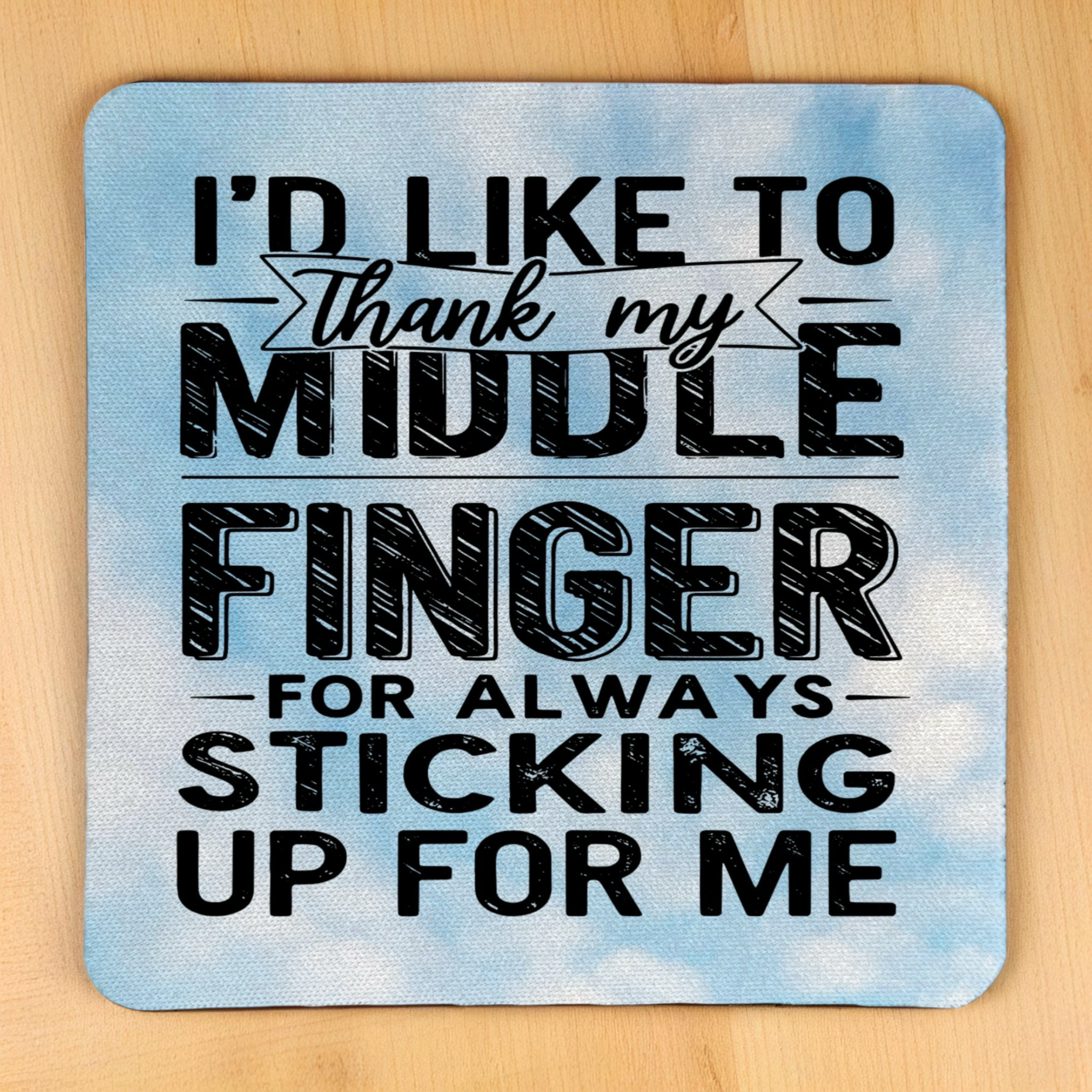 Top view of Thank My Middle Finger neoprene coaster with the sarcastic quote set against a blue sky, by Laser Design Creations.