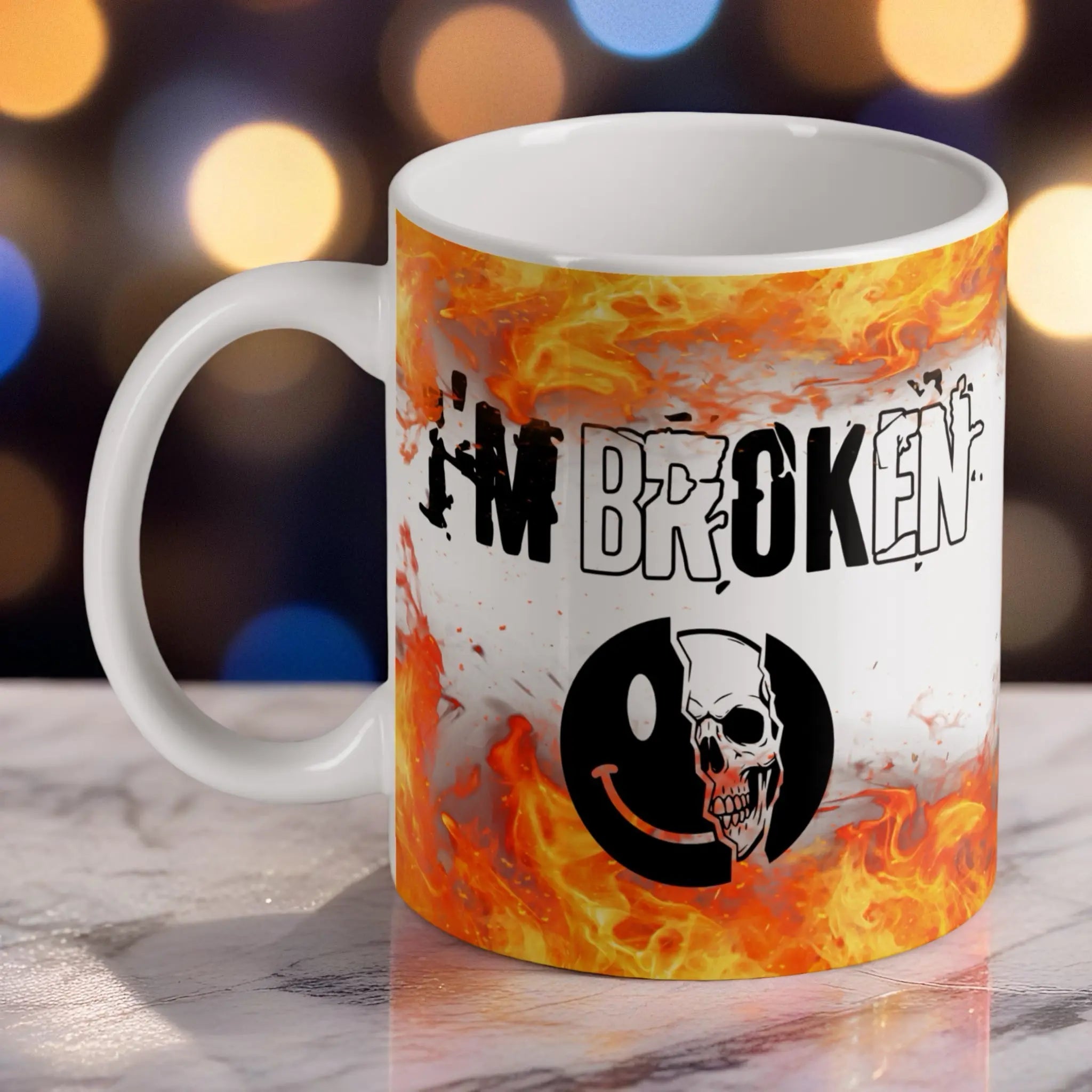 I'm Broken Skull Smiley ceramic mug by Laser Design Creations, featuring a split graphic of a happy smiley face saying I'm Ok and a skull saying I'm Broken on a flaming dark grunge background.
