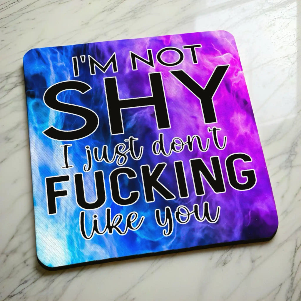 Side view of I'm Not Shy I Don't Like You neoprene coaster with a slim black rubber base beneath the vibrant purple watercolour nebula design, by Laser Design Creations.