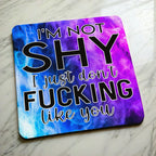 Side view of I'm Not Shy I Don't Like You neoprene coaster with a slim black rubber base beneath the vibrant purple watercolour nebula design, by Laser Design Creations.